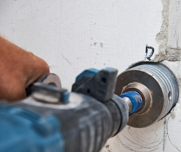 Builder with hummer drill perforatBore hul til DUKA tilbud København & Nordsjælland or drills hole in a wall